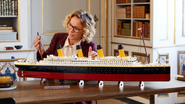 woman assembling lego model of Titanic