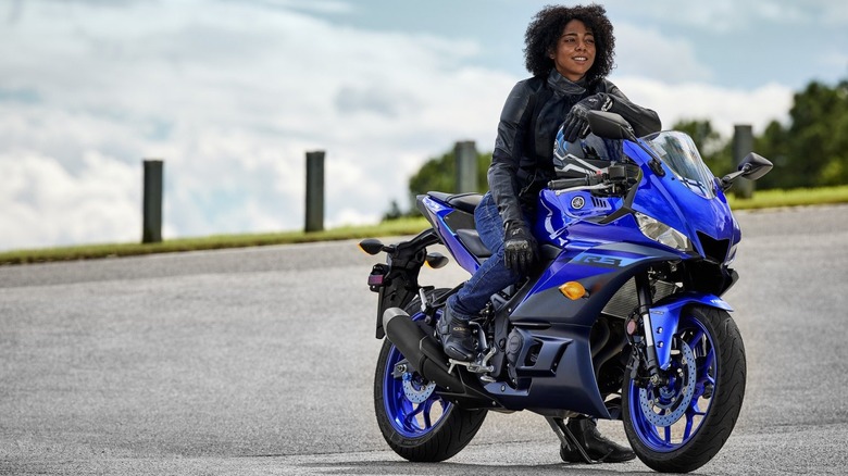 Woman astride a blue yamaha yzf-r3