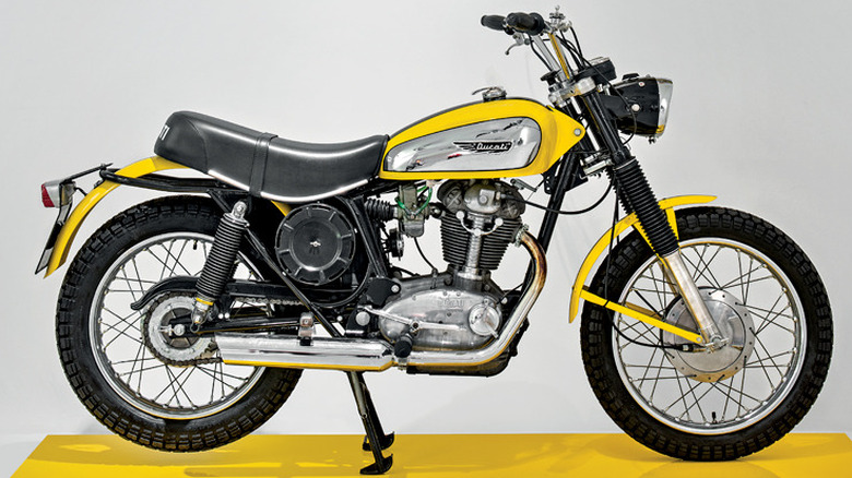 Yellow Ducati Scrambler on display stand in museum