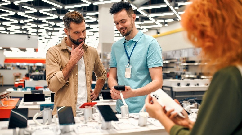 A consultant displaying a phone to a customer in a store