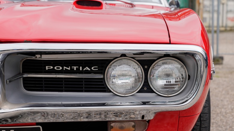 Red Pontiac Firebird with logo name on grill