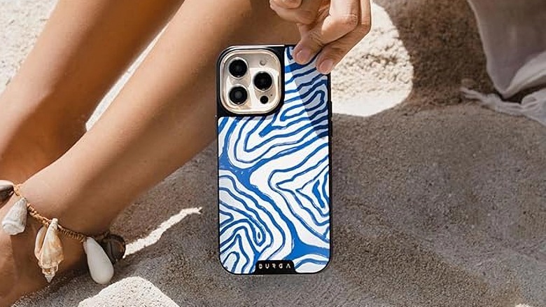 Holding phone at beach