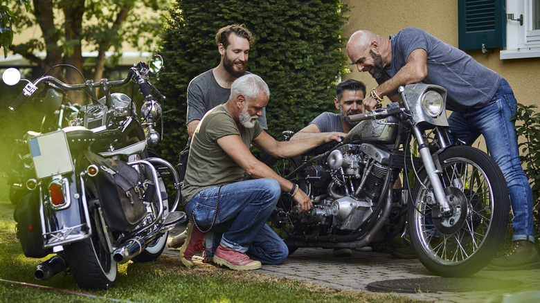 Motorcycle enthusiasts inspecting a bike