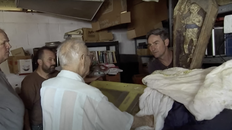 Mike Wolfe posing next to Wolf Boy papier-mache figure in mini coffin