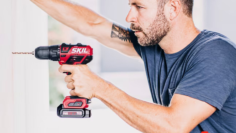 person using skil drill