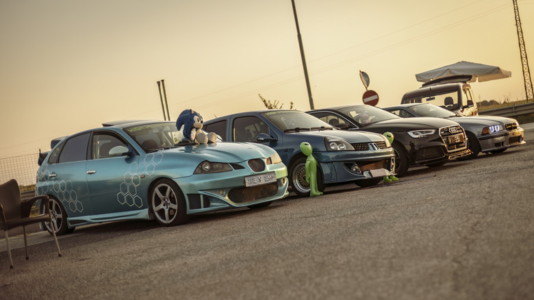 Various tuner cars parked at car show