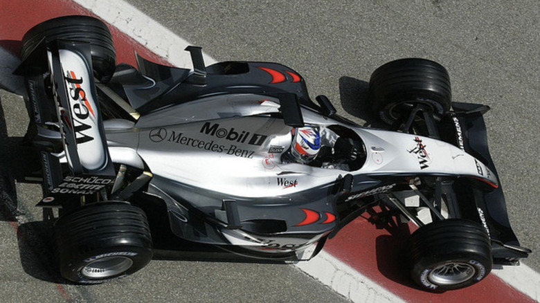 White McLaren Mp4/18 with black trimming on race-track