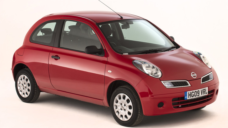 red third-gen Nissan Micra on white background