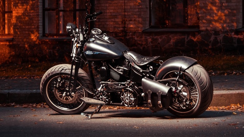 A customized silver Harley-Davidson in front of a brick building