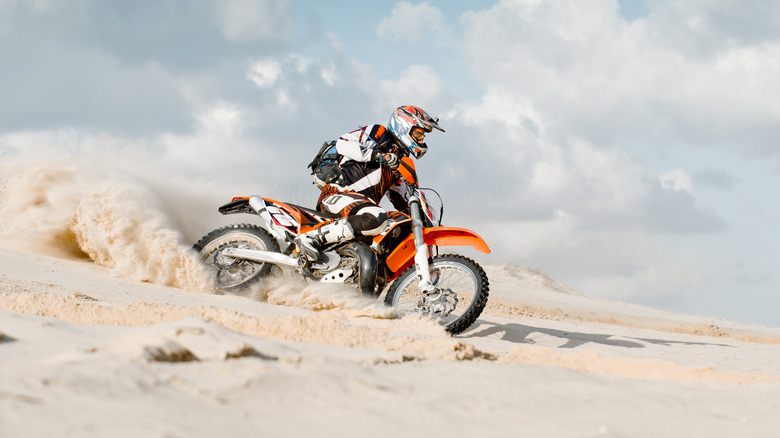 An orange and white Suzuki DR-Z 400 being ridden in dirt