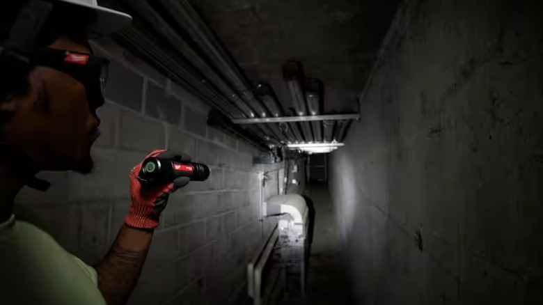 Flashlight lighting up a cement hallway