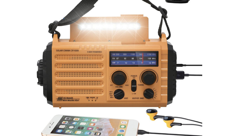 An orange Mesqool emergency radio and power charger replenishing a connected smartphone's battery