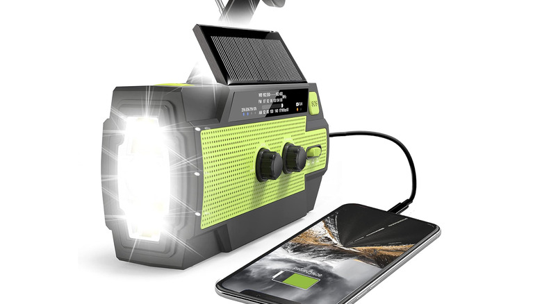 green RunningSnail hand crank radio recharging a phone via wired connection