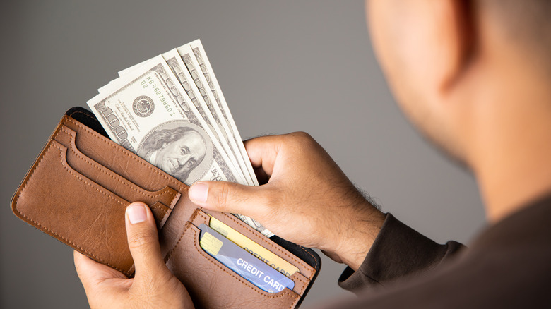 man removing money from wallet