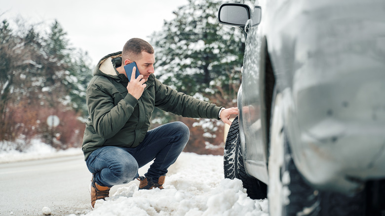 man with snow with tire