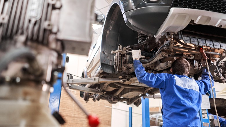 car mechanic inspecting suspension