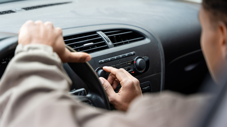 A man in tuning the air conditioning controls