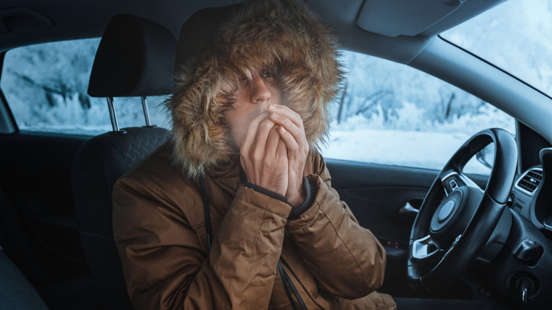 Man in down jacket tries to keep warm