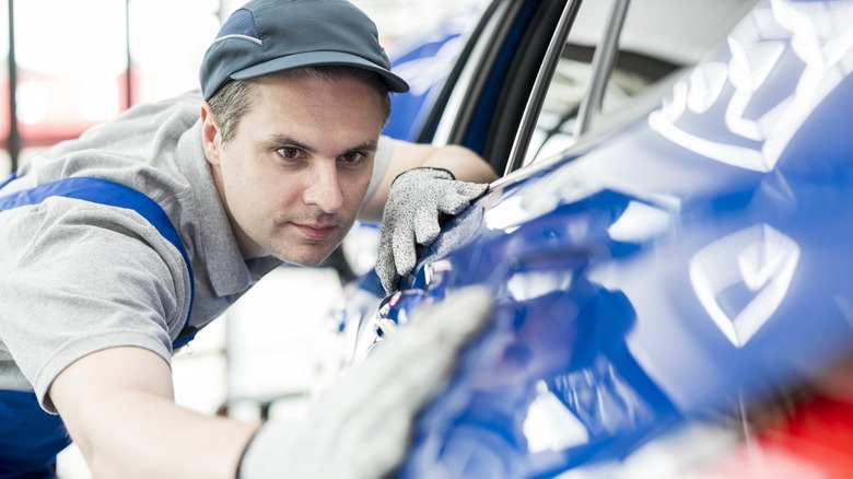 Man inspect car's bodywork