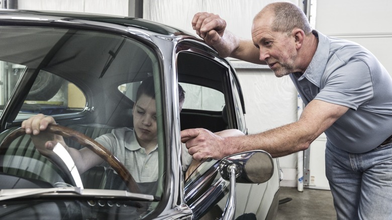 Man showing kid how to drive