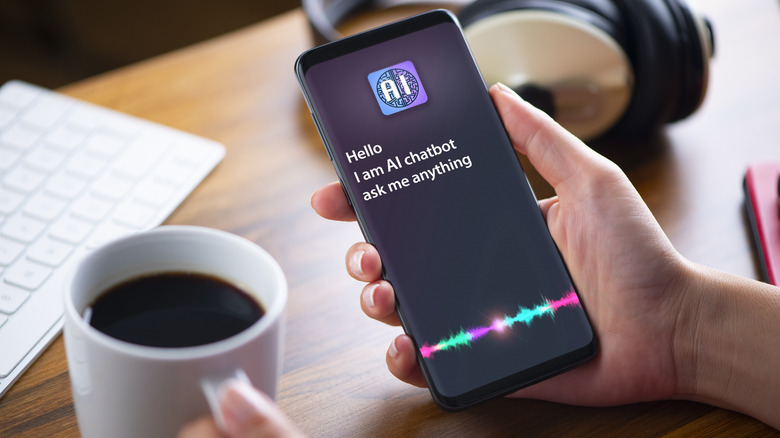 AI chatbot on smartphone with coffee, keyboard, and headphones in the background