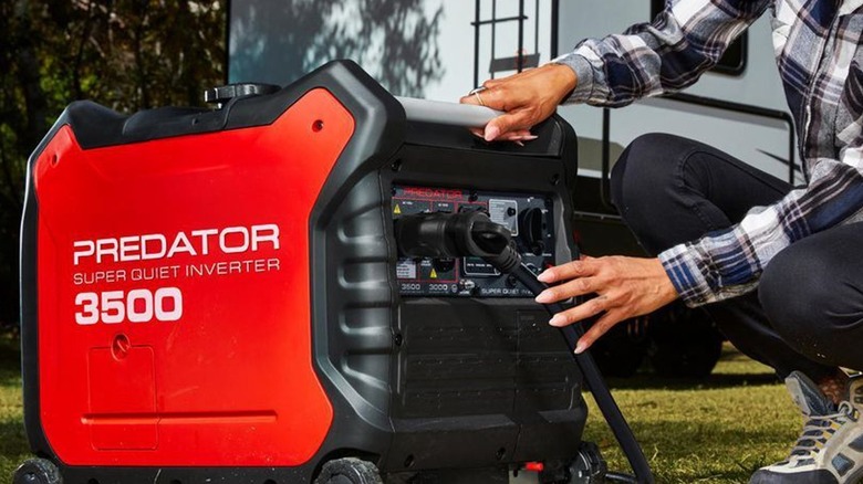 Person inspecting Predator 3500 generator outdoors