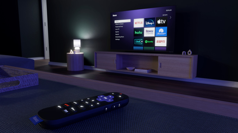 Roku remote on table with Roku TV in background