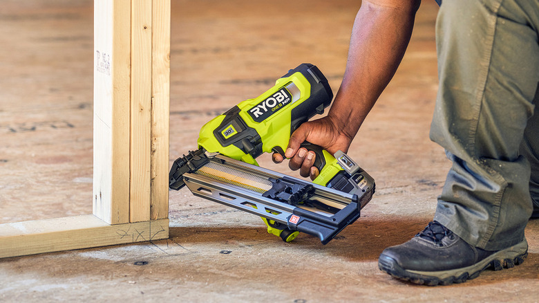 person using ryobi nail gun