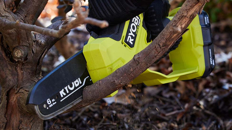 person using Ryobi chainsaw