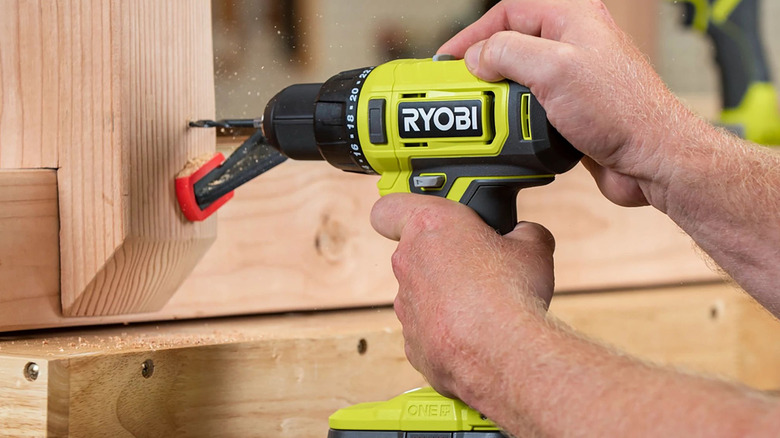 person using ryobi power drill