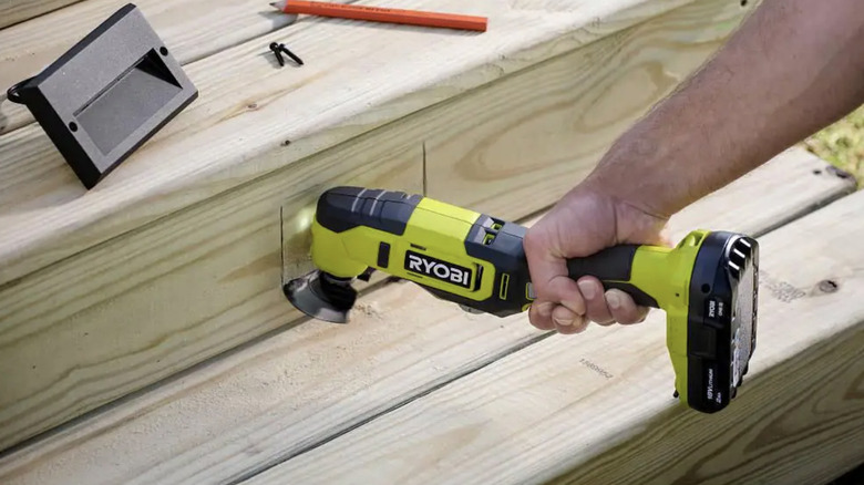 Person cutting wood with multi-tool