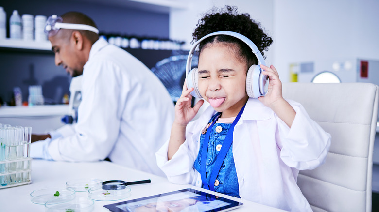 Girl on labcoat listening to music