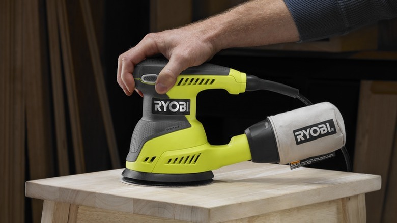 Person using a Ryobi 5-inch Random Orbit Sander