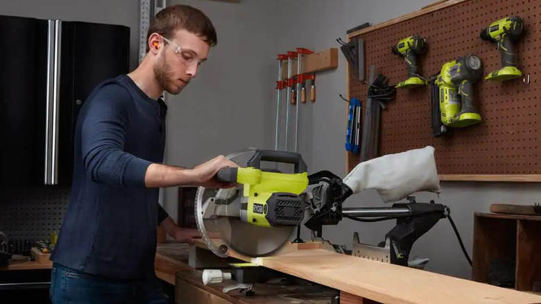 Person using Ryobi compound miter saw