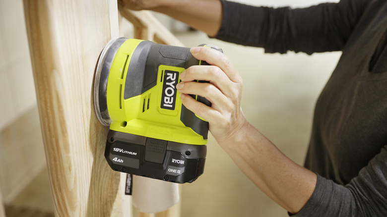 Person using Ryobi cordless orbit sander