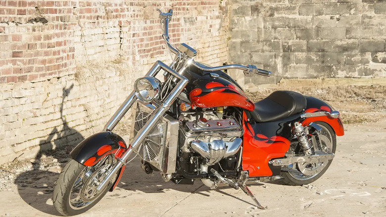 Red and black Boss Hoss V8 motorcycle parked in front of brick and cinderblock walls