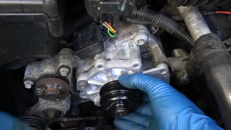 A person installing a new water pump