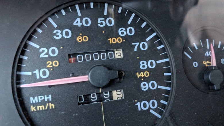 A car's odometer showing 100,000 miles