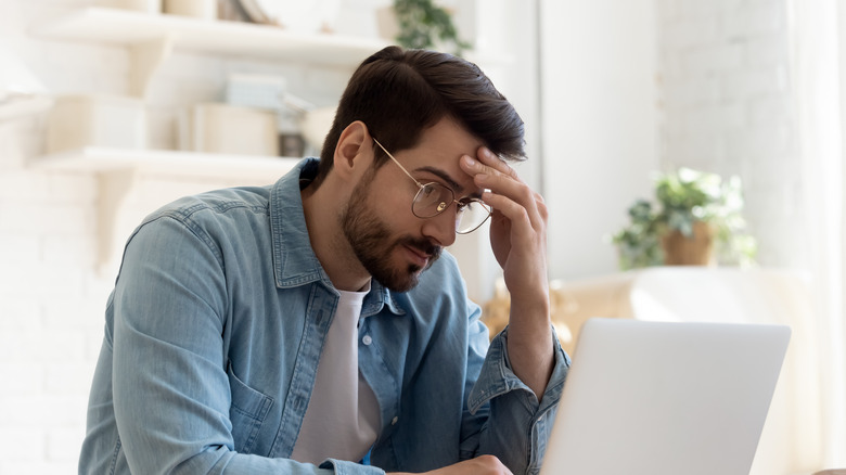 person stressed in front of laptop