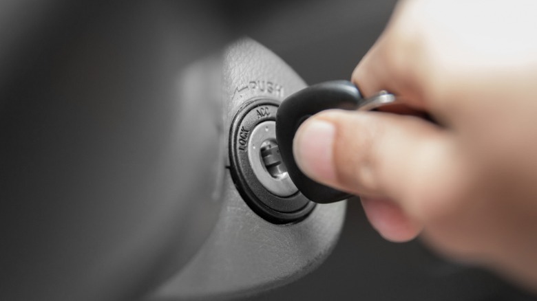 person turning car key