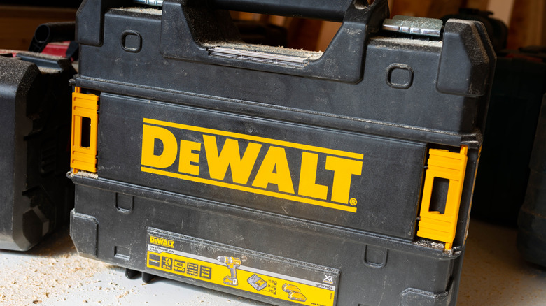 Man putting tools into Milwakuee Packout Rolling Tool Box