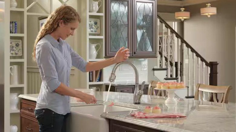 Woman using Delta Leland faucet