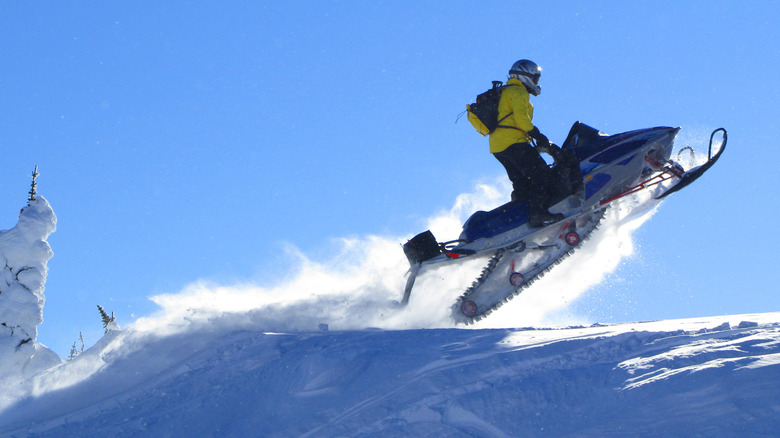 Snowmobile rider jumps