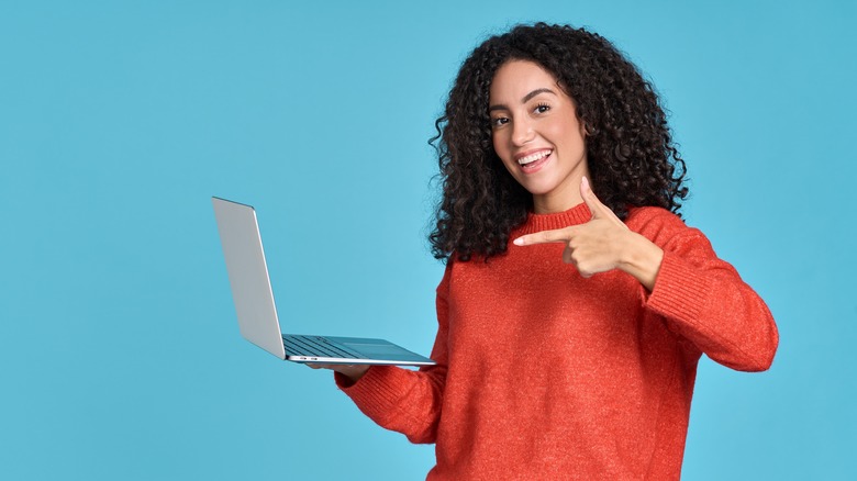 woman pointing at laptop on blue background