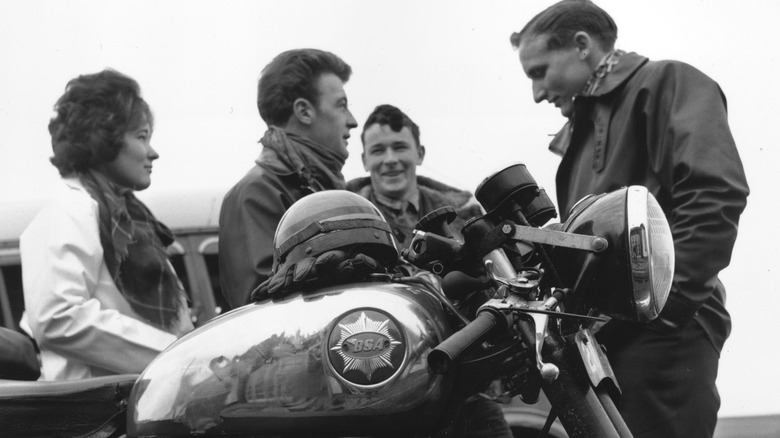 People standing next to a BSA motorcycle