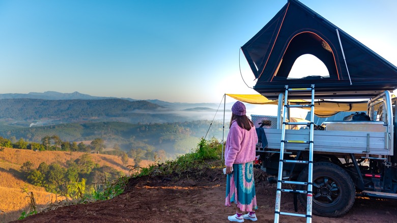 woman watching sunrise while overlanding