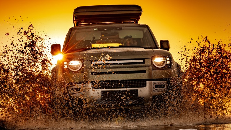 Overlanding vehicle splashing through mud