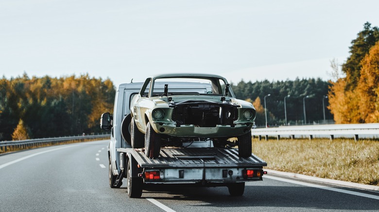 The remains of a 1967 Mustang on a tow truck