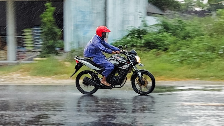 Riding motorcycle in blue rain suit