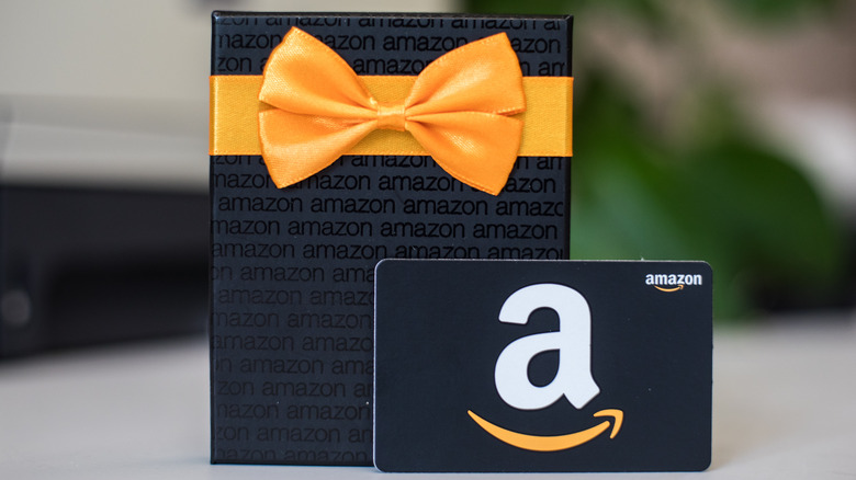 A black Amazon gift card with box